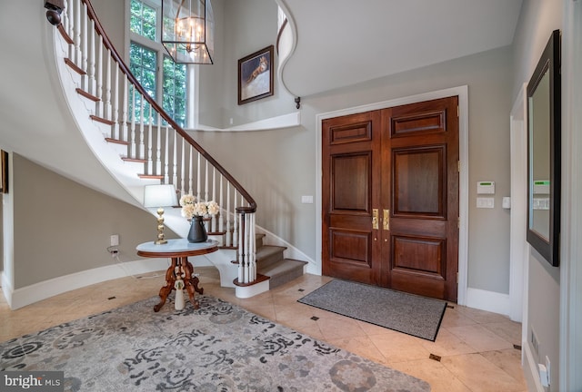 tiled entryway featuring a chandelier