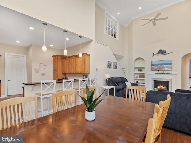 dining area with ceiling fan, built in features, and ornamental molding