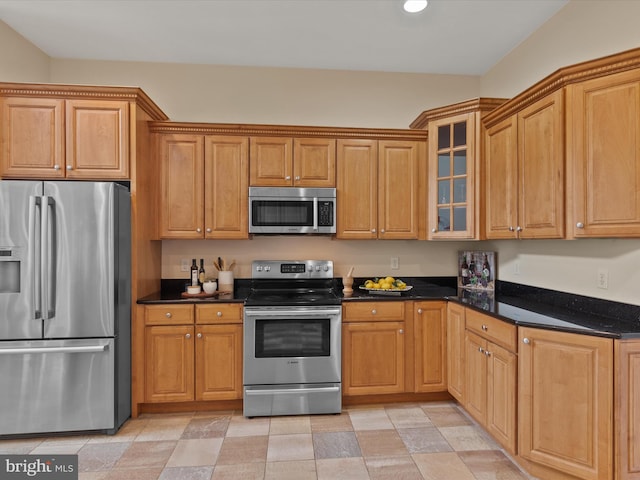 kitchen featuring appliances with stainless steel finishes and dark stone counters