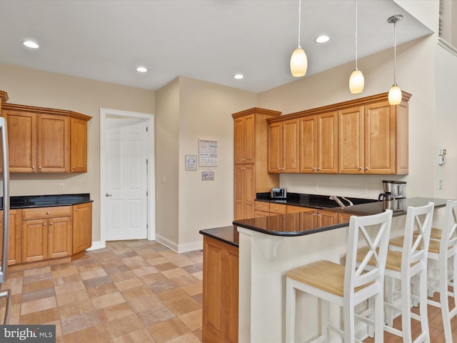 kitchen with a kitchen breakfast bar, kitchen peninsula, and pendant lighting