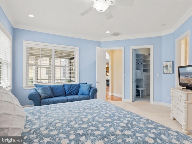 carpeted bedroom with multiple windows, a walk in closet, a closet, and ceiling fan