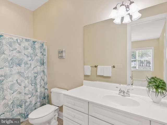 bathroom featuring toilet, vanity, and an inviting chandelier