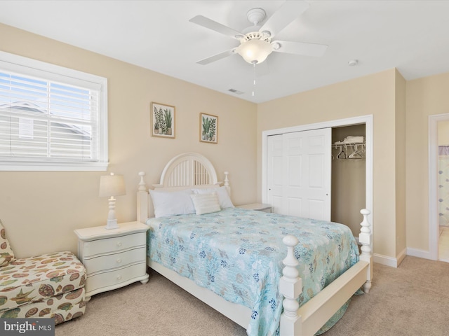 carpeted bedroom featuring ceiling fan and a closet