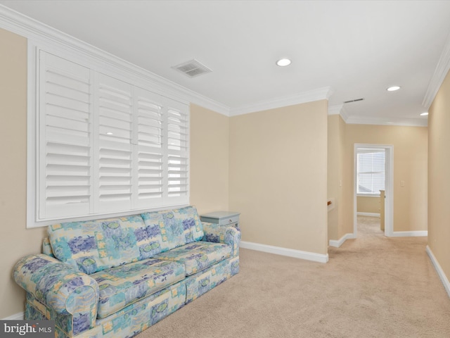 sitting room with ornamental molding and light carpet