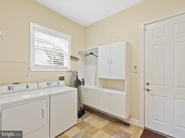 washroom featuring washer and clothes dryer and cabinets