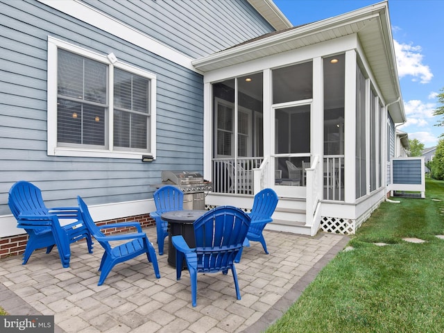 view of patio / terrace featuring a sunroom and an outdoor fire pit