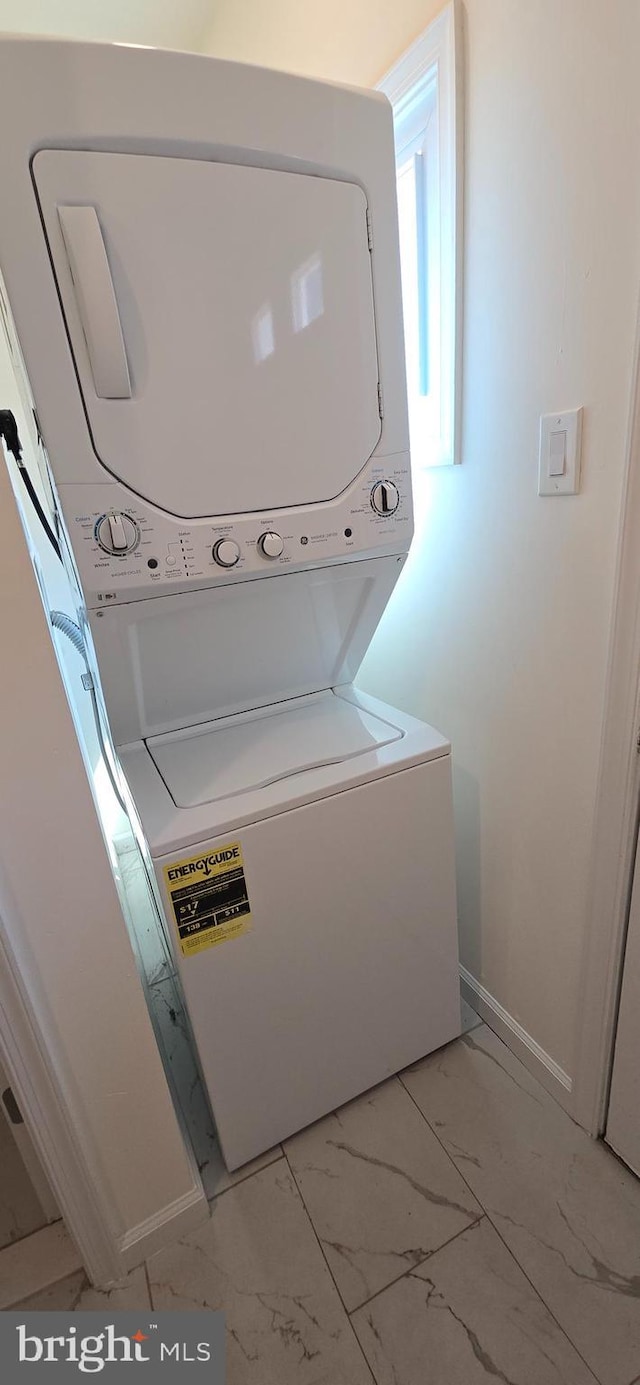 clothes washing area featuring stacked washing maching and dryer