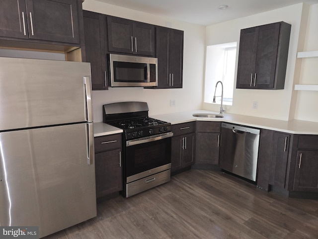 kitchen with dark wood-type flooring, dark brown cabinetry, stainless steel appliances, and sink