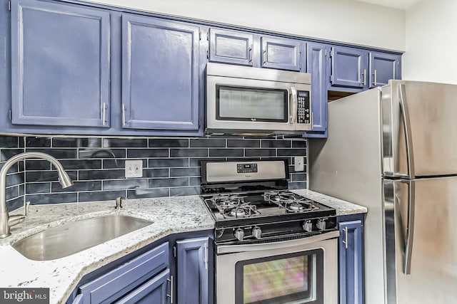 kitchen featuring stainless steel appliances, blue cabinets, and sink