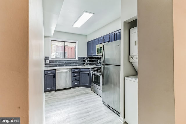 kitchen featuring backsplash, appliances with stainless steel finishes, sink, and light hardwood / wood-style floors