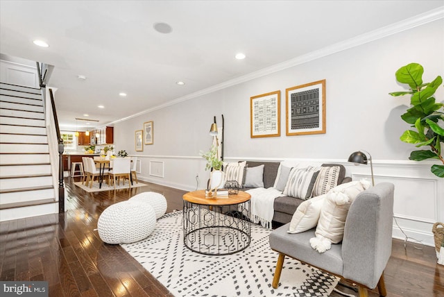 living area with a wainscoted wall, stairway, ornamental molding, hardwood / wood-style floors, and a decorative wall