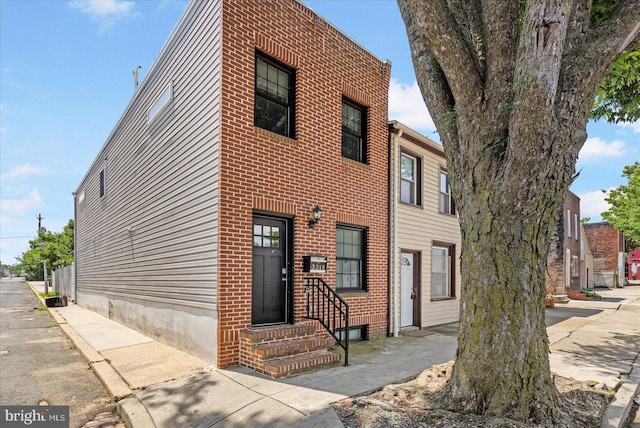 view of front of property featuring entry steps and brick siding