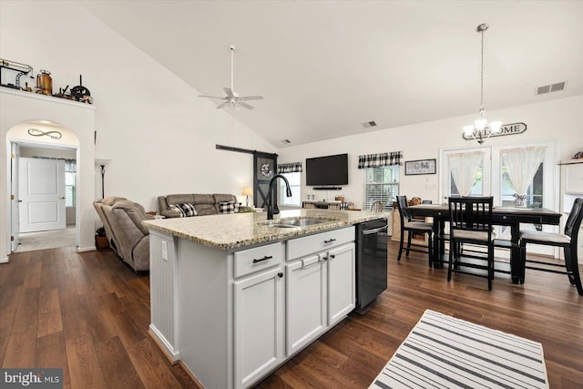 kitchen with white cabinetry, sink, light stone counters, stainless steel dishwasher, and a center island with sink