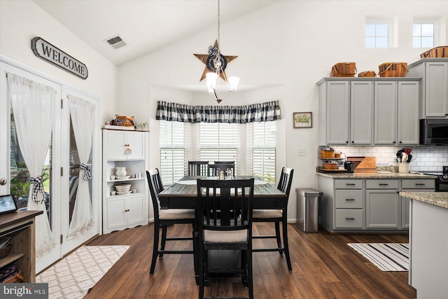 dining area with vaulted ceiling and dark hardwood / wood-style flooring