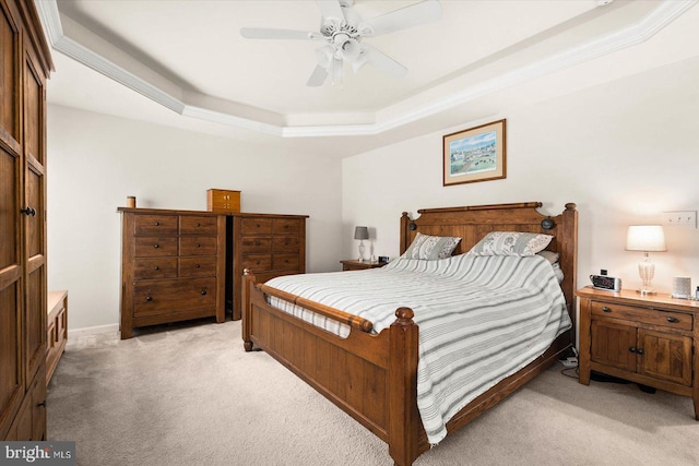 bedroom featuring ceiling fan, light carpet, and a raised ceiling