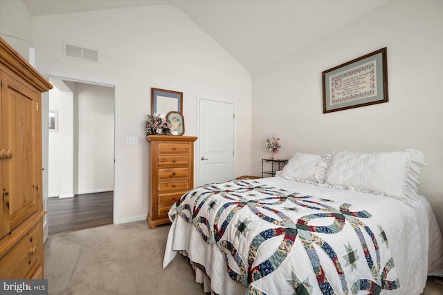 bedroom with carpet floors and high vaulted ceiling