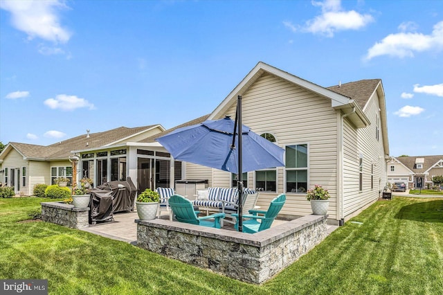 rear view of house featuring a sunroom, a jacuzzi, a yard, and a patio