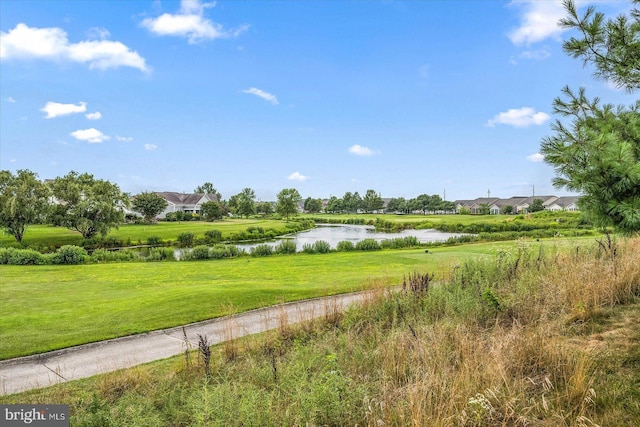 surrounding community featuring a lawn and a water view