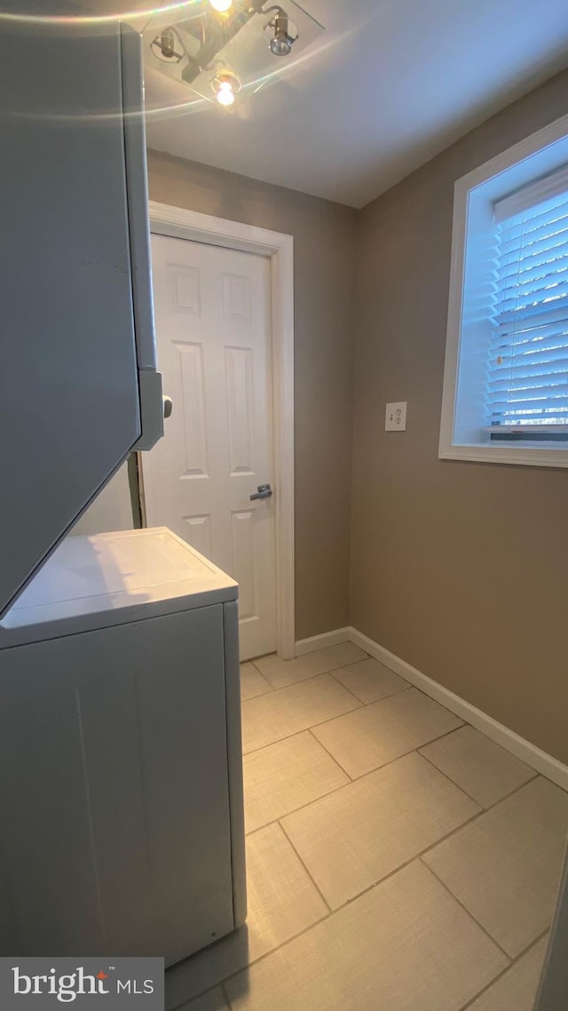 washroom with laundry area, baseboards, and washer / clothes dryer