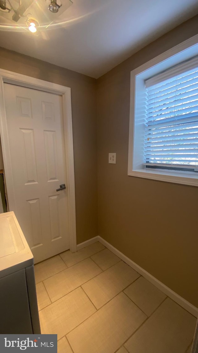 interior space featuring light tile patterned floors and baseboards