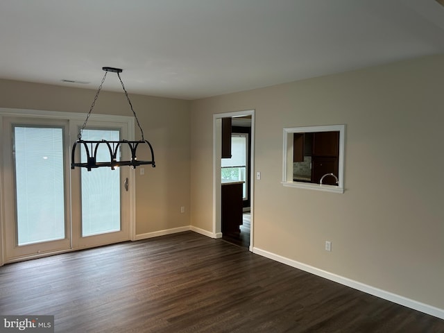 unfurnished dining area with dark wood-type flooring