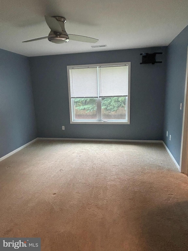 empty room featuring ceiling fan and light colored carpet