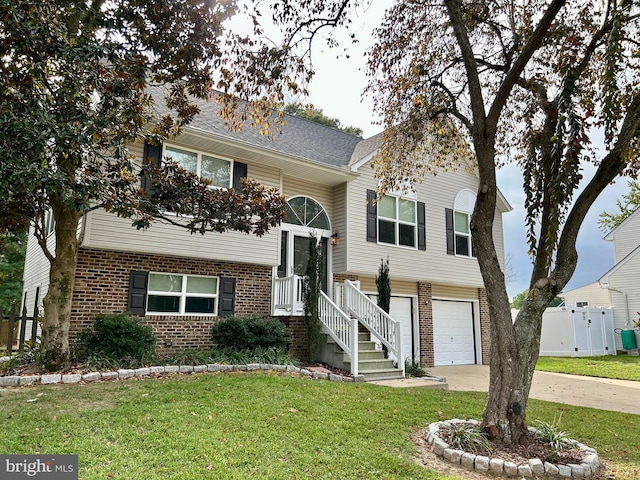 raised ranch with a front lawn and a garage