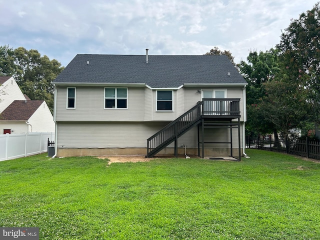 back of property with a deck, central air condition unit, and a lawn