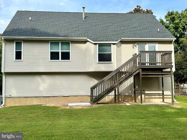 rear view of property with a deck and a lawn