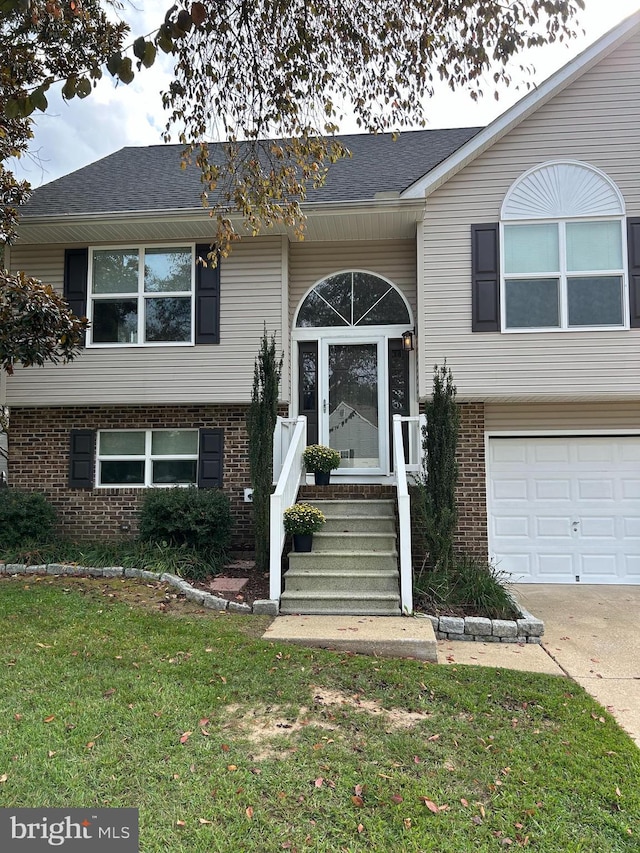 raised ranch with a garage and a front lawn