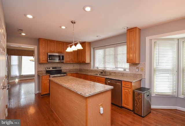 kitchen featuring dark hardwood / wood-style floors, stainless steel appliances, and plenty of natural light