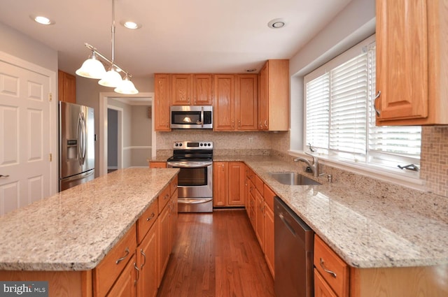 kitchen featuring backsplash, dark hardwood / wood-style flooring, light stone countertops, appliances with stainless steel finishes, and sink