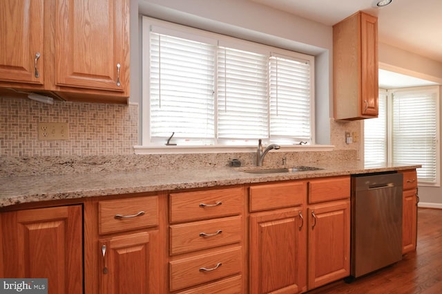 kitchen with stainless steel dishwasher, backsplash, dark hardwood / wood-style floors, and a wealth of natural light