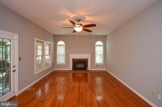 unfurnished living room with hardwood / wood-style flooring, a fireplace, and ceiling fan