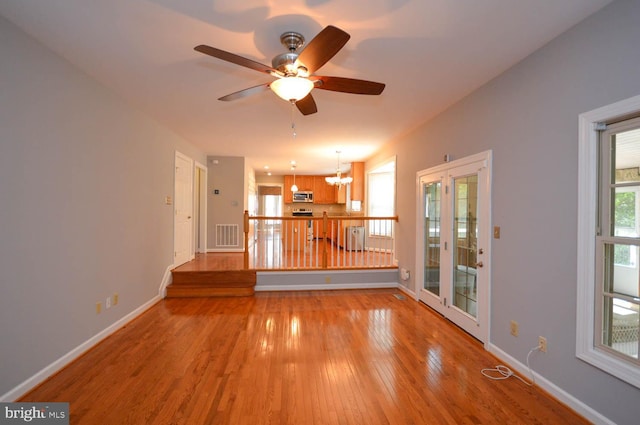 unfurnished living room with ceiling fan and wood-type flooring