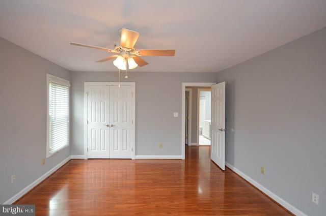 unfurnished bedroom featuring a closet, hardwood / wood-style floors, and ceiling fan