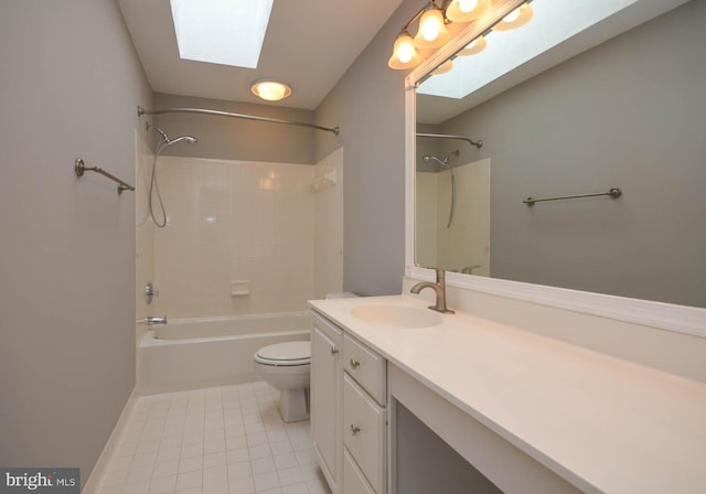 full bathroom with tiled shower / bath, tile patterned floors, toilet, a skylight, and vanity