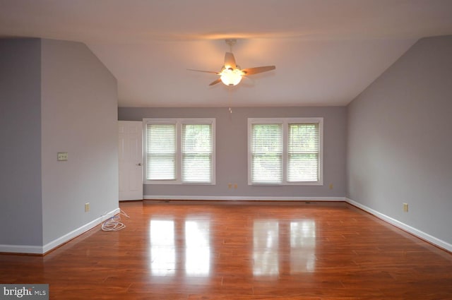 empty room featuring wood-type flooring, ceiling fan, and vaulted ceiling