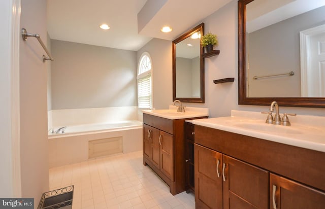 bathroom featuring tile patterned flooring, a washtub, and double sink vanity