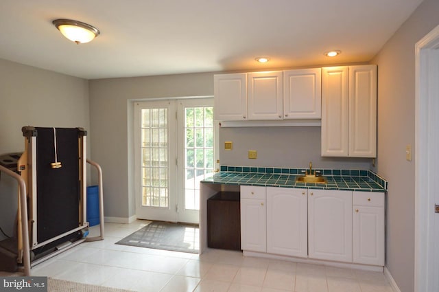 kitchen with white cabinetry, tile countertops, and light tile patterned floors