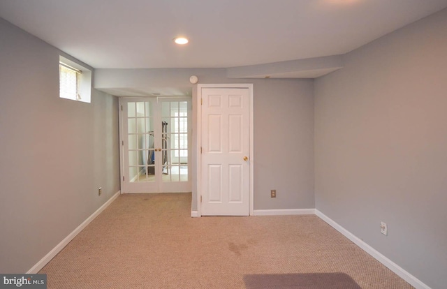 carpeted spare room featuring french doors