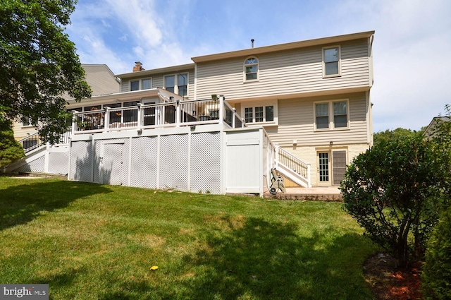 rear view of property with a deck and a lawn