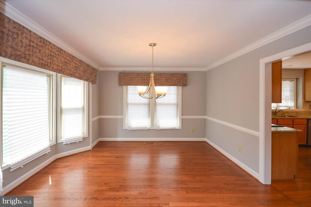 unfurnished dining area with a notable chandelier, a healthy amount of sunlight, and hardwood / wood-style floors