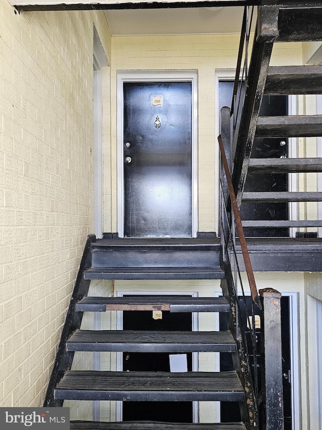 staircase featuring brick wall