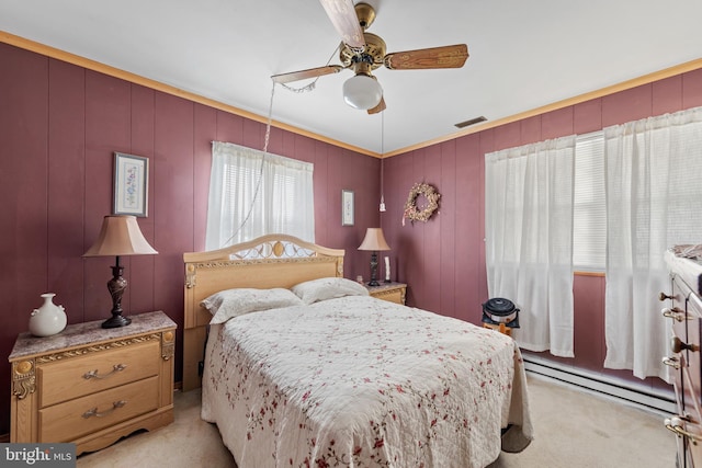 carpeted bedroom with a baseboard heating unit, ornamental molding, and ceiling fan