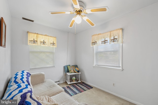 sitting room with baseboard heating, ceiling fan, and carpet flooring