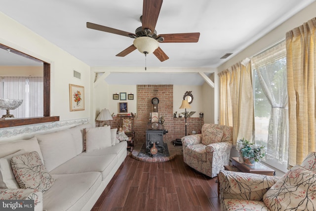 living room featuring ceiling fan, a wood stove, and dark hardwood / wood-style floors