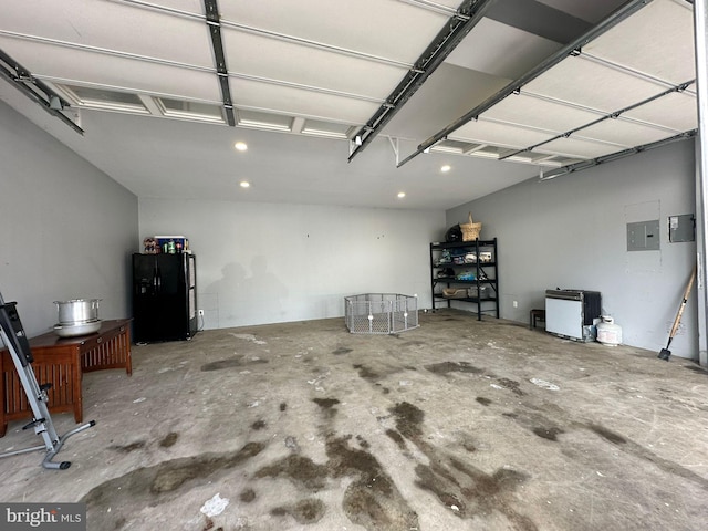 garage with electric panel and black fridge