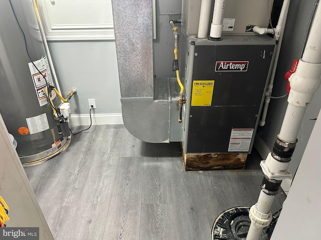 utility room featuring gas water heater and heating unit