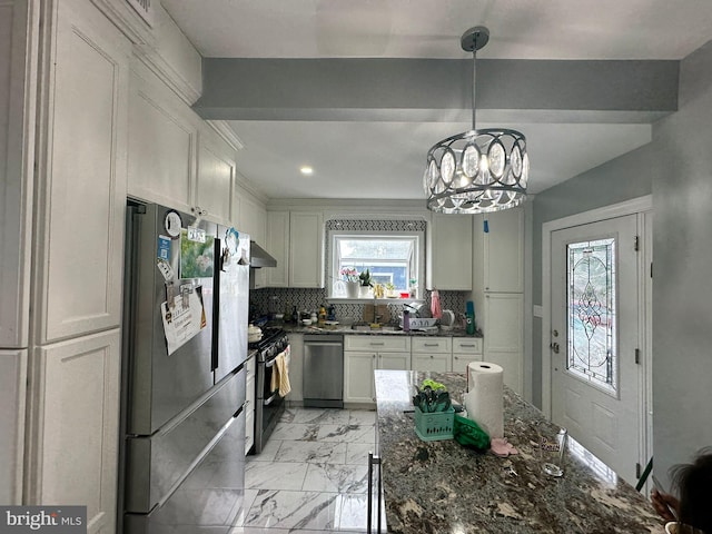 kitchen with hanging light fixtures, tasteful backsplash, a notable chandelier, white cabinets, and appliances with stainless steel finishes